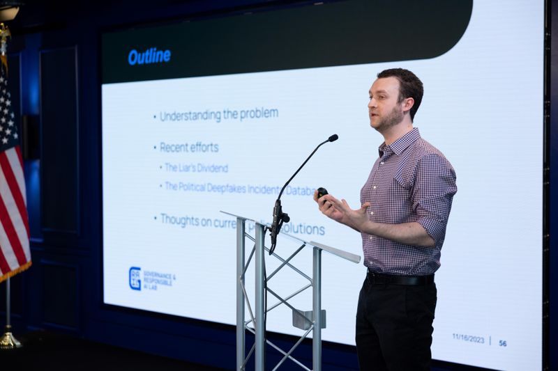A GRAIL researcher presenting from a podium beside a slide carrying the GRAIL logo.